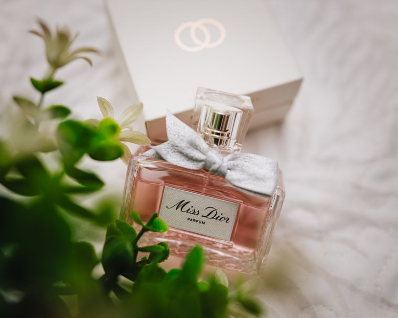 Close-up of a Miss Dior perfume bottle with soft floral background.